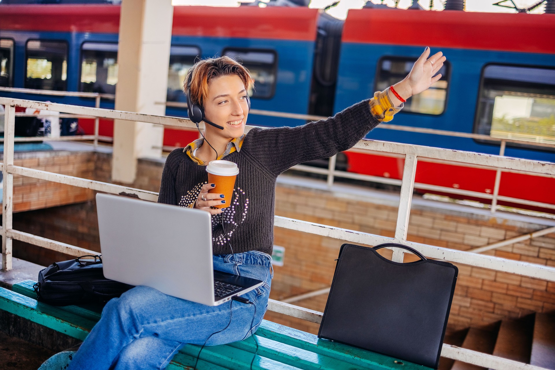 Young woman waving to someone on railway station